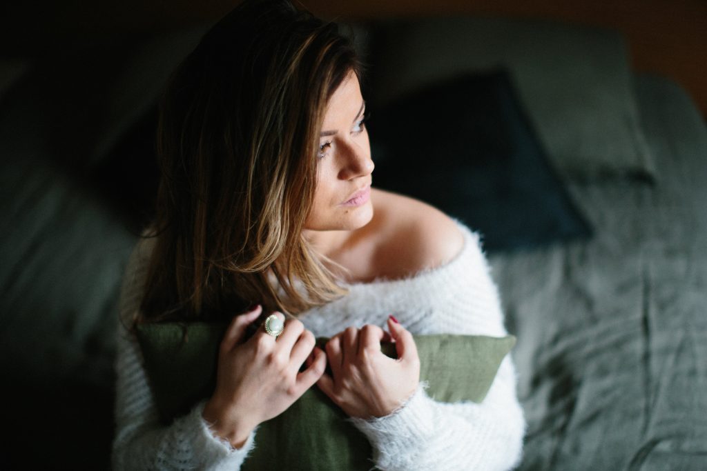 Photographie d'une jeune femme qui tient un coussin dans les mains