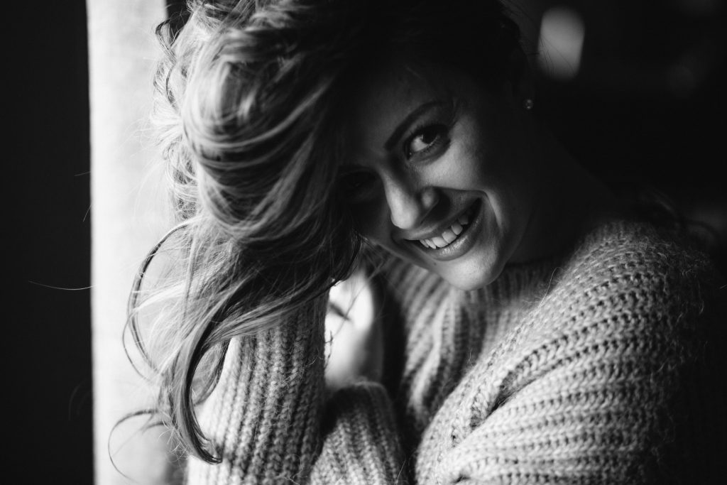 Photographie en noir et blanc d'une femme vêtue d'un pull clair à grosse maille
