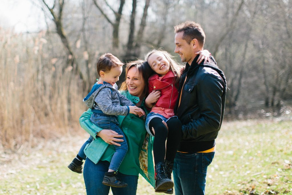 Portrait de famille avec deux parents et deux enfants en train de sourire