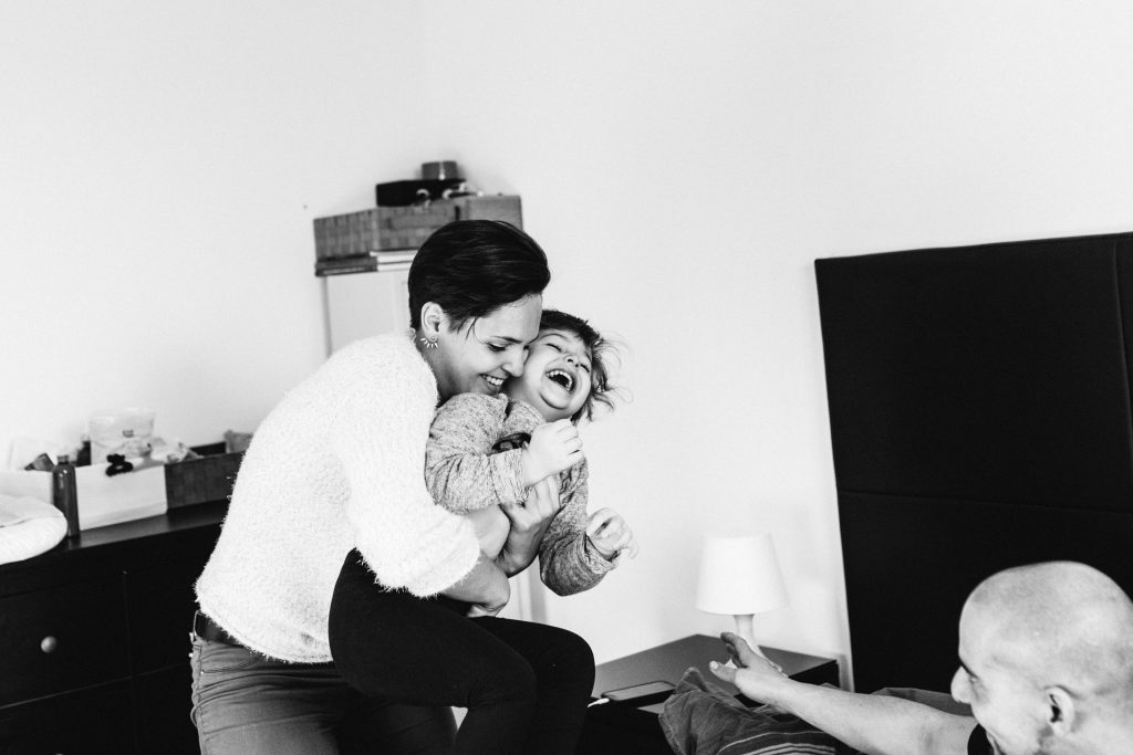 Photographie en noir et blanc d'un moment de rire entre une maman et sa fille