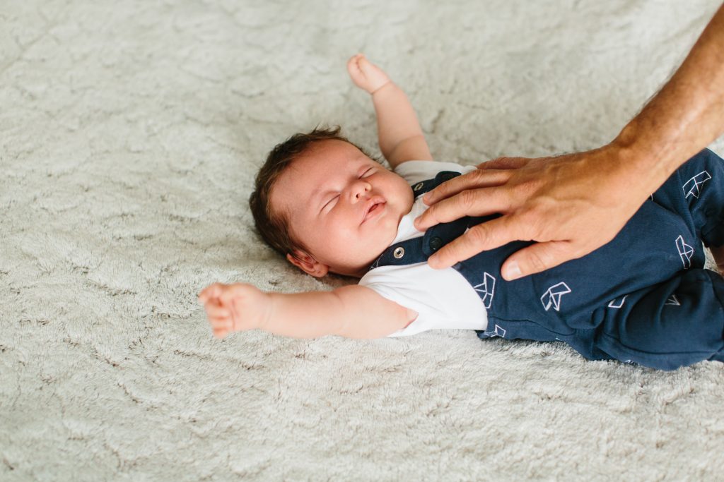 Papa essaye de réveiller bébé lors de la séance photo
