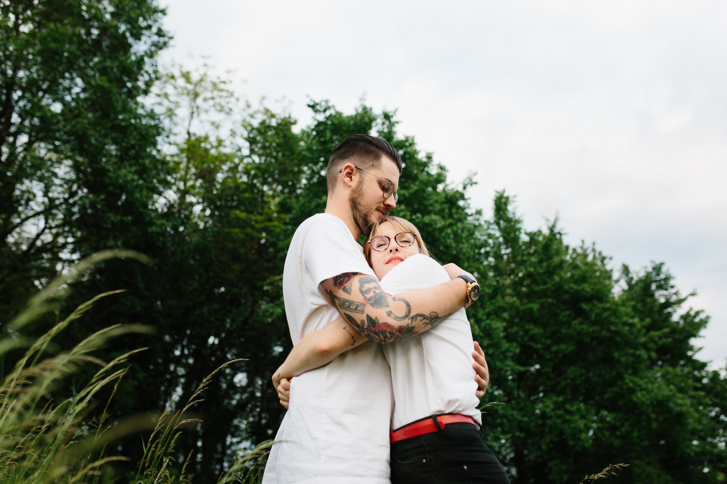 Couple se prenant dans les bras devant une forêt