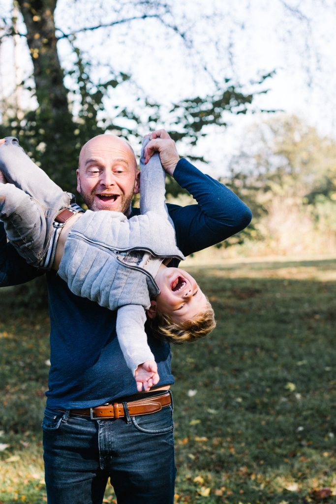 Photographie d'un papa en train de faire rire son enfant
