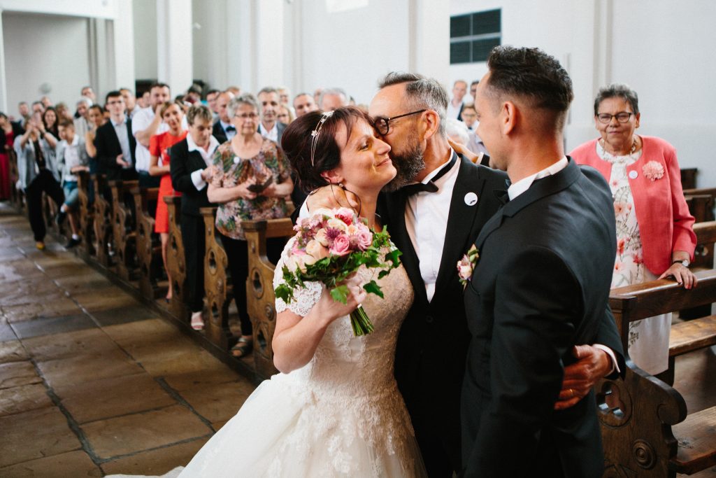 Père de la mariée qui embrasse sa fille devant l'autel