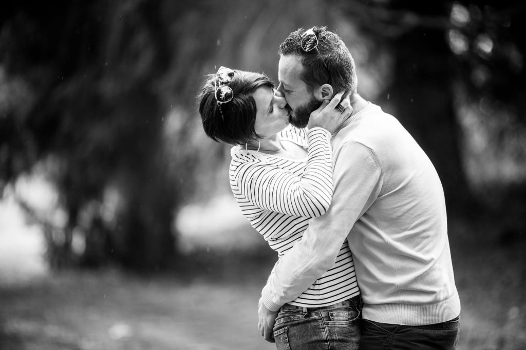 portrait noir et blanc d'un couple s'embrassant sous la pluie